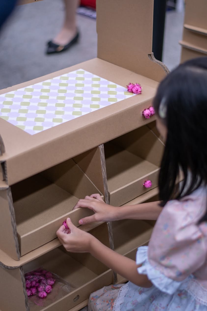 A child proudly displaying their handmade eco toy