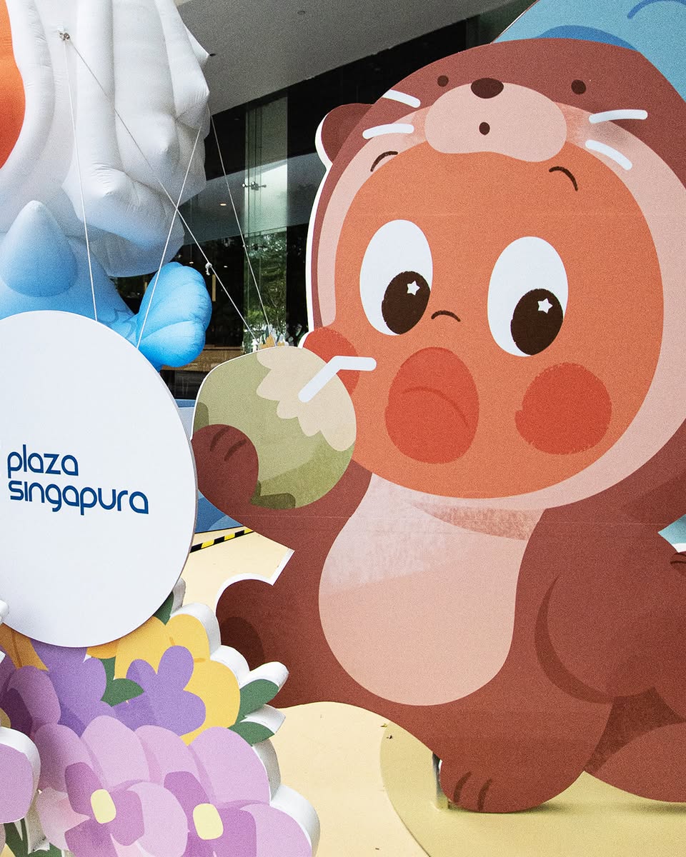 Cartoon otter character with coconut drink at Plaza Singapura